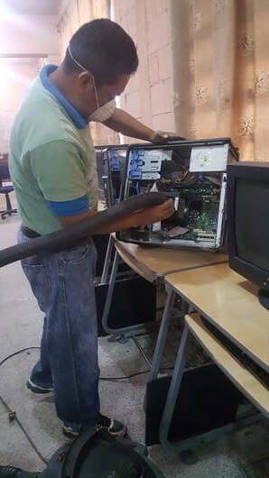 empleado de cr compumania realizando mantenimiento preventivo de computadora